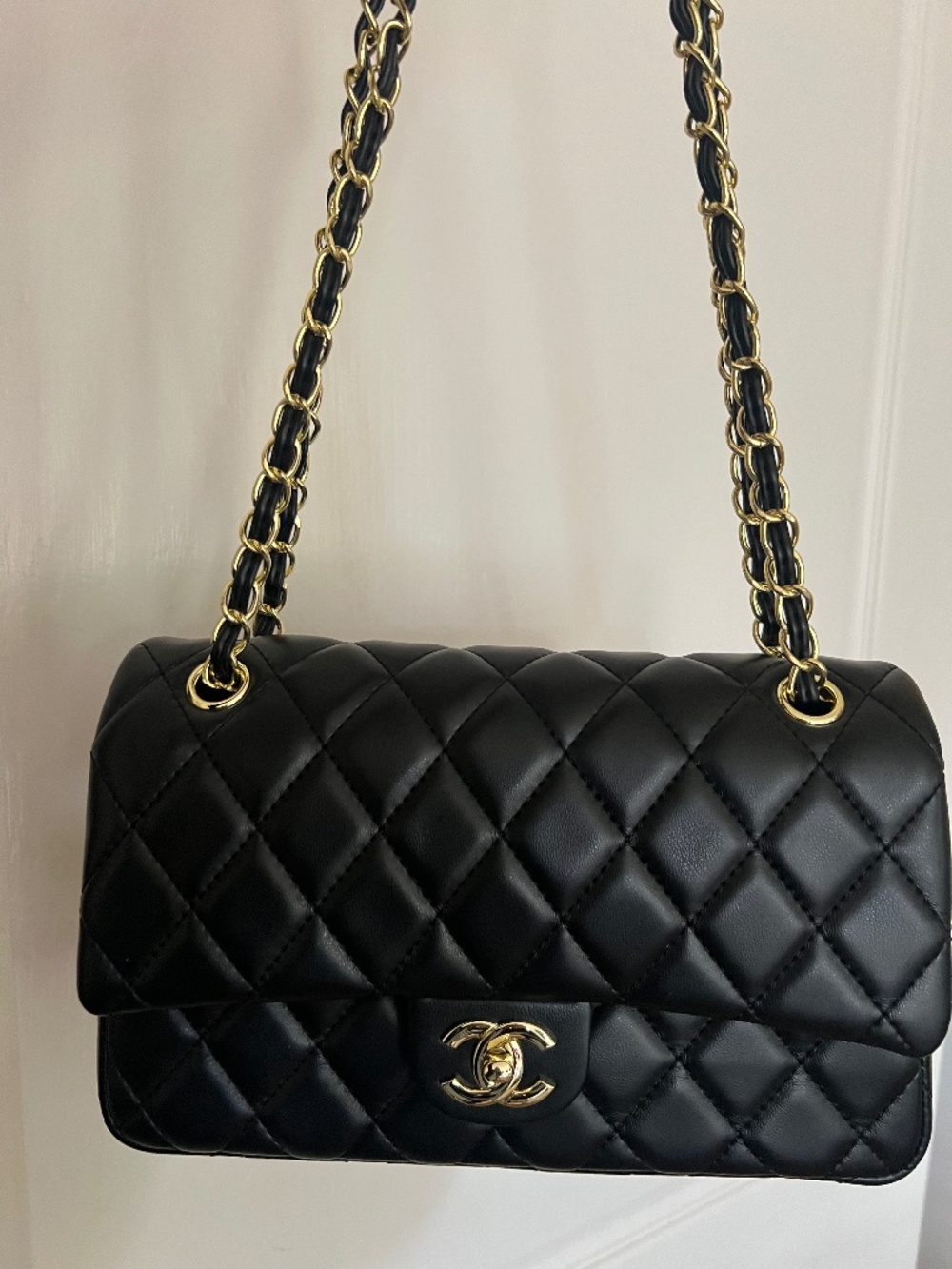 Black Quilted Shoulder Bag with Gold Tone Chain and Pink Scarf Accent